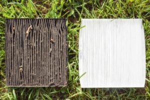 dirty and clean vehicle air filters on the green grass